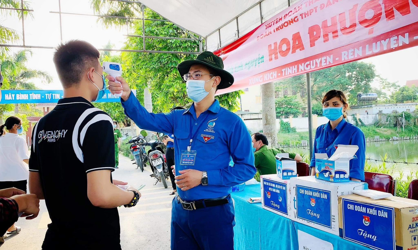 Cán bộ đoàn, thanh niên tình nguyện hỗ trợ đo thân nhiệt cho thí sinh trước khi vào phòng thi. Ảnh: Nguyễn Tư Hải Phong. Cán bộ đoàn, thanh niên tình nguyện hỗ trợ đo thân nhiệt cho thí sinh trước khi vào phòng thi. Ảnh: Nguyễn Tư Hải Phong.