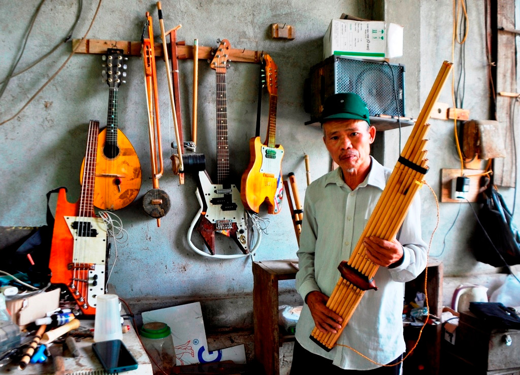 Ông Kha Văn Hưng cùng hàng chục nhạc cụ do chính tay mình tự chế.
