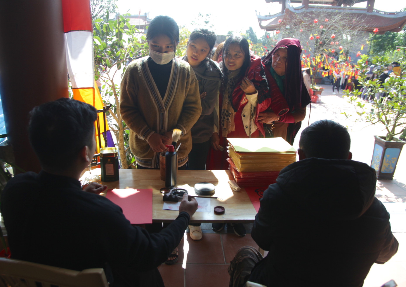 Để đáp ứng nhu cầu của người dân đến xin chữ, phía nhà chùa đã bố trí 4 điểm viết chữ. Ở mỗi điểm sẽ có 1 thầy đồ và 1 người phục vụ để viết và phát chữ.