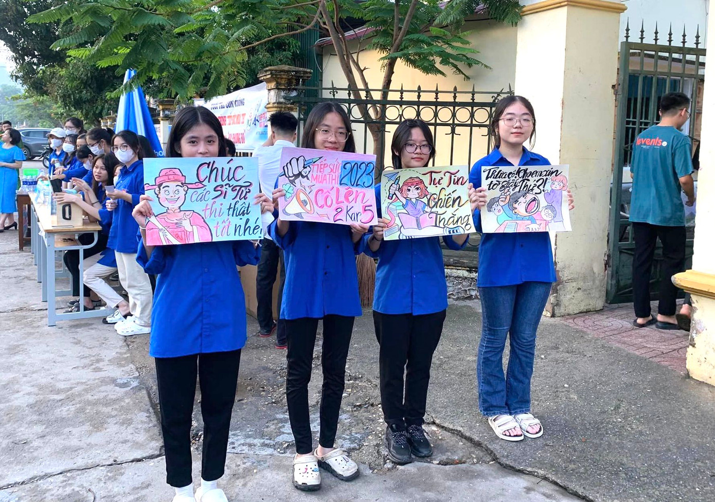 Những bóng hồng đứng trước cổng các điểm thi giơ cao những bức tranh cổ vũ cho các thí sinh tự tin làm bài.