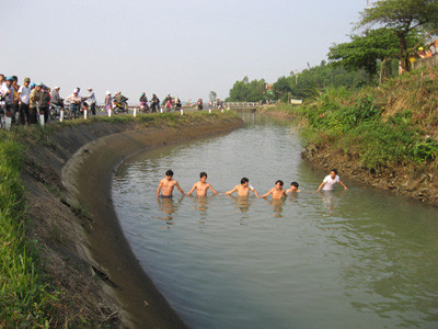 Lực lượng cứu hộ dùng lưới B40 tìm kiếm người bị nạn dưới nước 