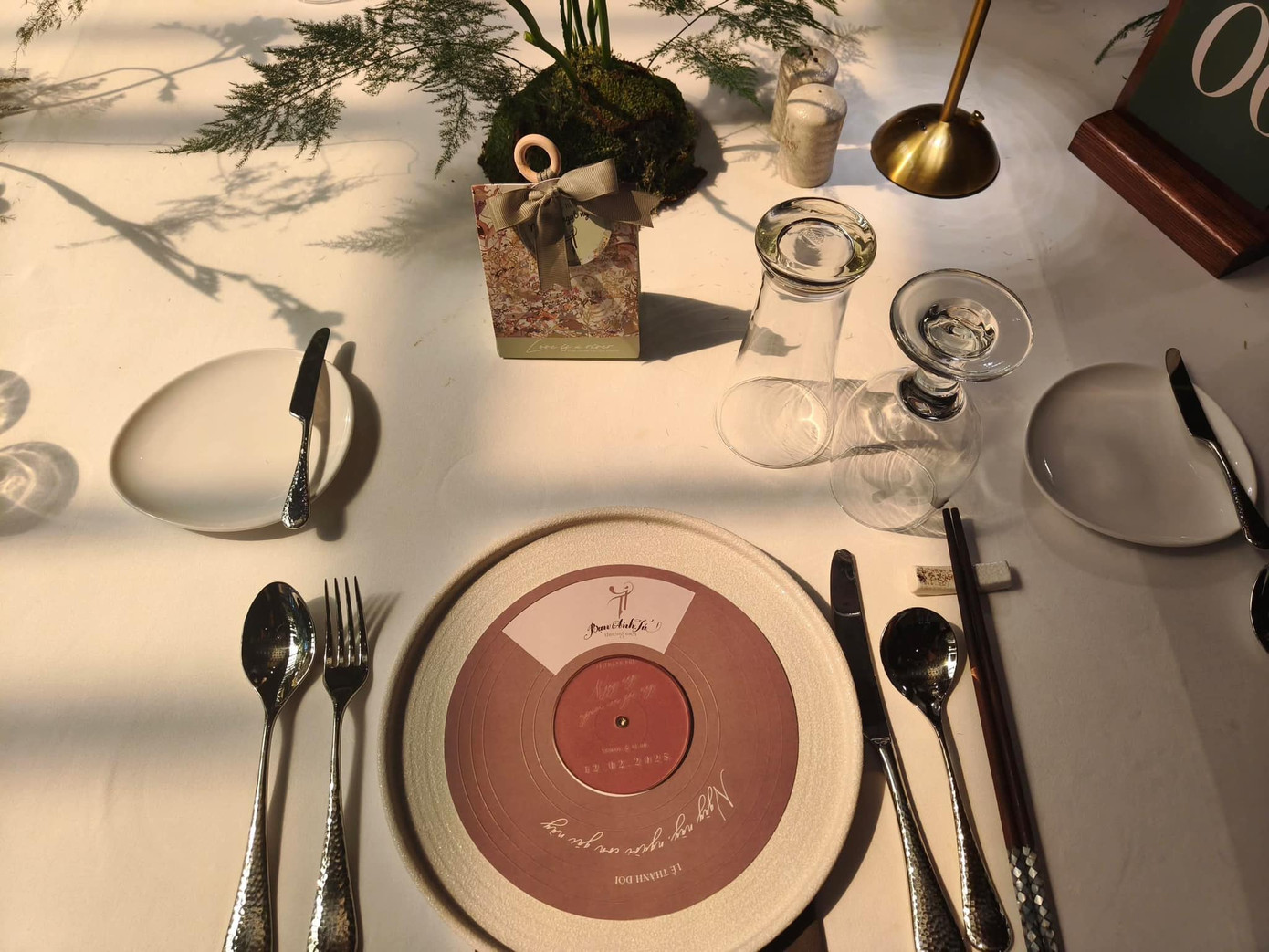 Bàn tiệc cũng được trang trí theo concept này khi sử dụng những chiếc đĩa ăn có thiết kế mô phỏng đĩa nhạc. Từng vật phẩm nhỏ như thiệp, menu hay quà tặng đều được thiết kế theo tone pastel nhẹ nhàng, tinh tế.