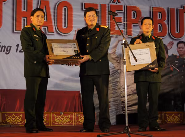 Thiếu tá Thái Đức Hạnh – Trưởng ban Thanh niên Quân đội (đứng giữa) trao tặng 2 bộ máy tính cho tuổi trẻ Quân khu 1