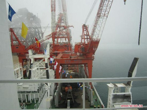 Các cần trục khổng lồ màu đỏ của tàu, trong đó có chiếc đạt tới độ cao tương đương tòa nhà 45 tầng. Ảnh: Xinhua 
