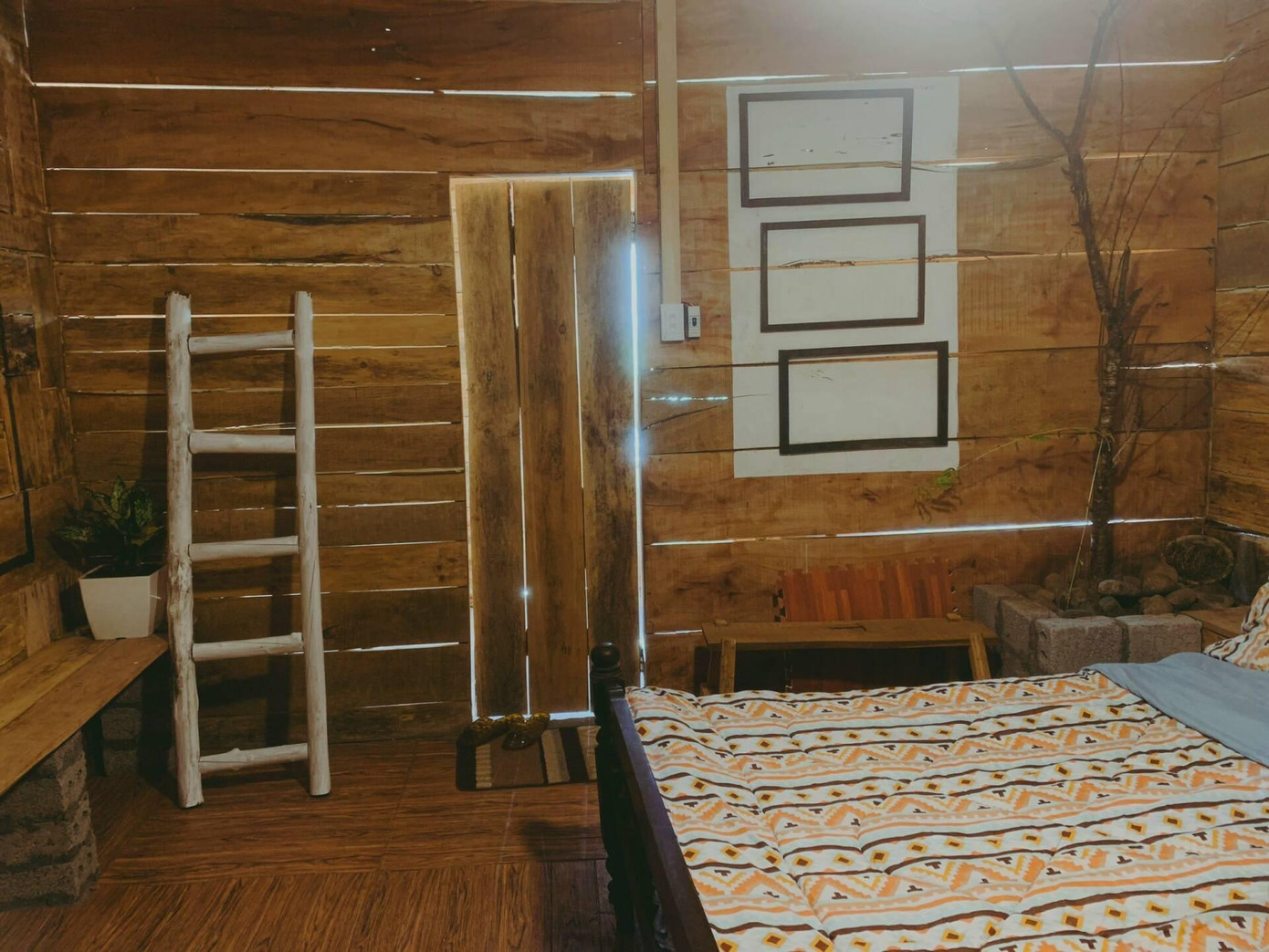 Lối vào phòng ngủ cũng làm bằng gỗ để tạo sự mộc mạc và ăn nhập với toàn bộ không gian.