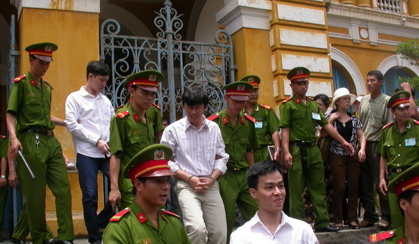 Nhà báo Hoàng Khương bị áp giải ra xe