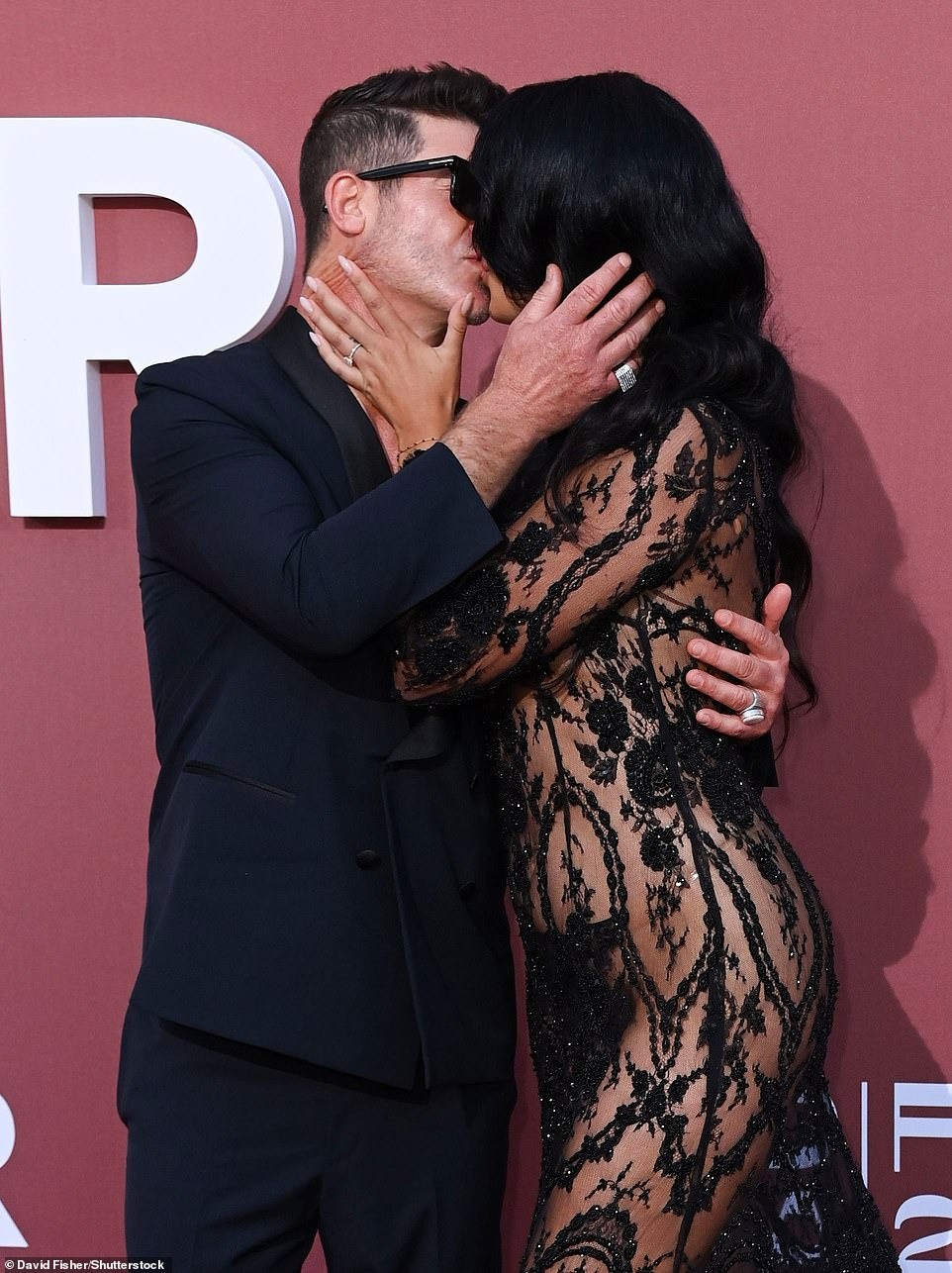 Nhạc sĩ/diễn viên Mỹ Robin Thicke sành điệu với vest đen và kính râm. Trong khi đó, bạn gái anh, người mẫu April Love Geary, khiến người nhìn &quot;nóng mặt&quot; với váy xuyên thấu mặc như không. Giống như Cher, cặp đôi 10 năm khoe nụ hôn nồng cháy. Ảnh: Shutterstock.