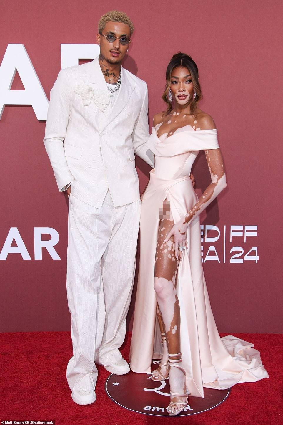 Cựu ngôi sao America&apos;s Next Top Model Winnie Harlow và bạn trai Kyle Kuzma đẹp đôi trên thảm đỏ amfAR Gala. Chiếc váy mà người mẫu áo tắm lựa chọn đẹp mắt, tôn được vóc dáng tuyệt đẹp của cô. Tuy nhiên, phần xẻ tà quá cao khiến cô hớ hênh lúc tạo dáng chụp ảnh. Ảnh: Shutterstock.