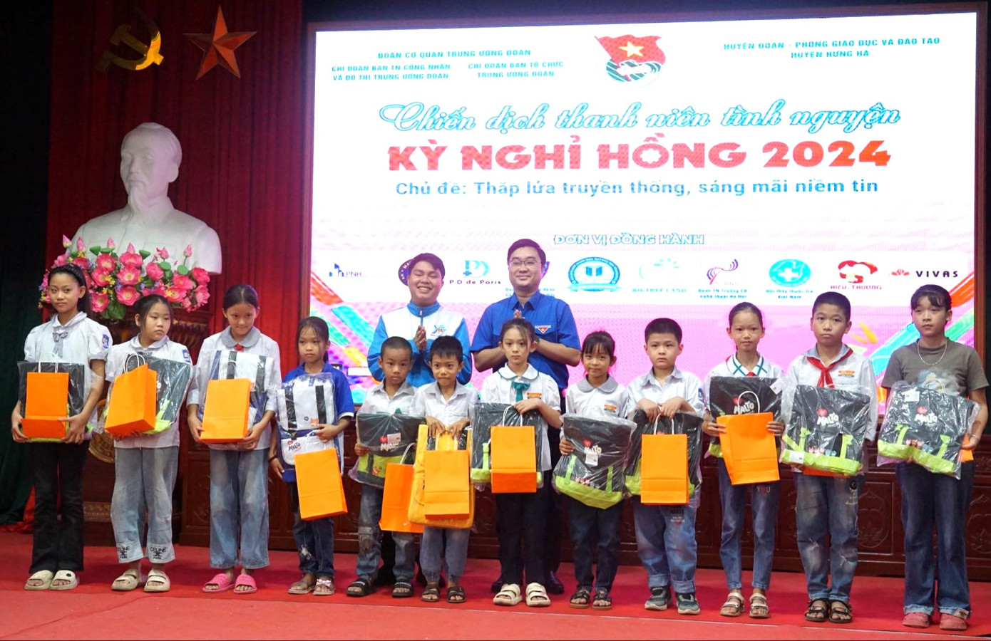 Anh Nguyễn Bá Cát - Phó Bí thư Tỉnh Đoàn Thái Bình (bìa phải, hàng sau) và anh Trương Chấn Sang - Chủ nhiệm CLB Tiếng Anh vì cộng đồng tặng quà cho thiếu nhi có hoàn cảnh khó khăn