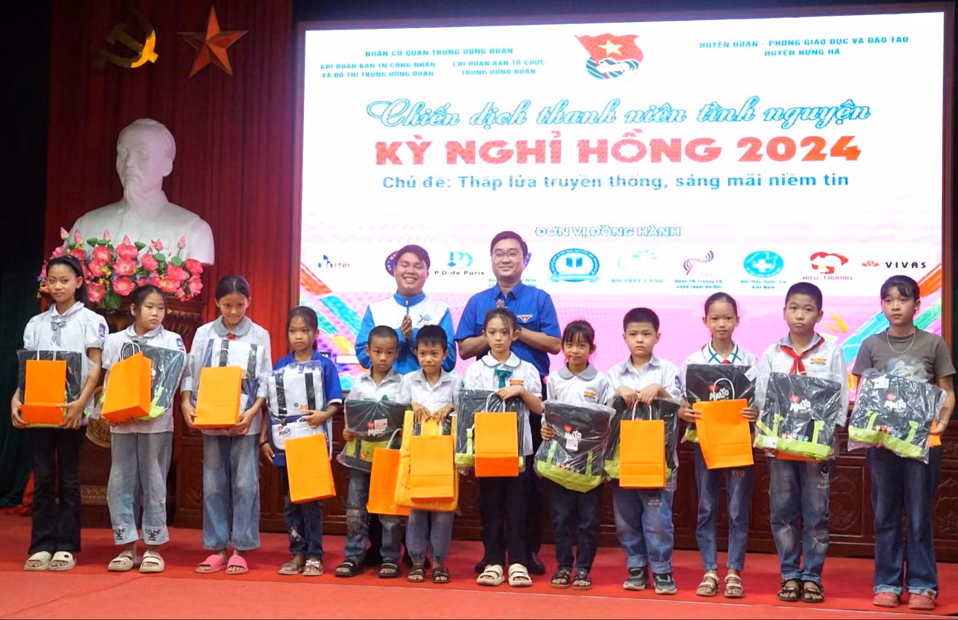 Anh Nguyễn Bá Cát - Phó Bí thư Tỉnh Đoàn Thái Bình (bìa phải, hàng sau) và anh Trương Chấn Sang - Chủ nhiệm CLB Tiếng Anh vì cộng đồng tặng quà cho thiếu nhi có hoàn cảnh khó khăn