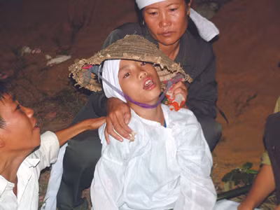 Cháu Trần Đình Quang vật vã bên quan tài bố, mẹ và em gái. Cháu Trần Đình Quang vật vã bên quan tài bố, mẹ và em gái