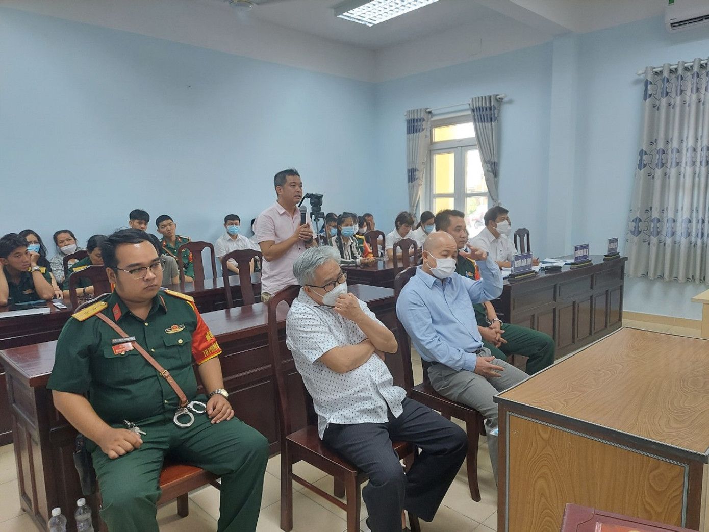 3 bị cáo trong vụ án tại tòa sáng nay. Ông Hệ và ông Diệt ngồi hàng ghế đầu, bị cáo Toàn đứng cầm micro.