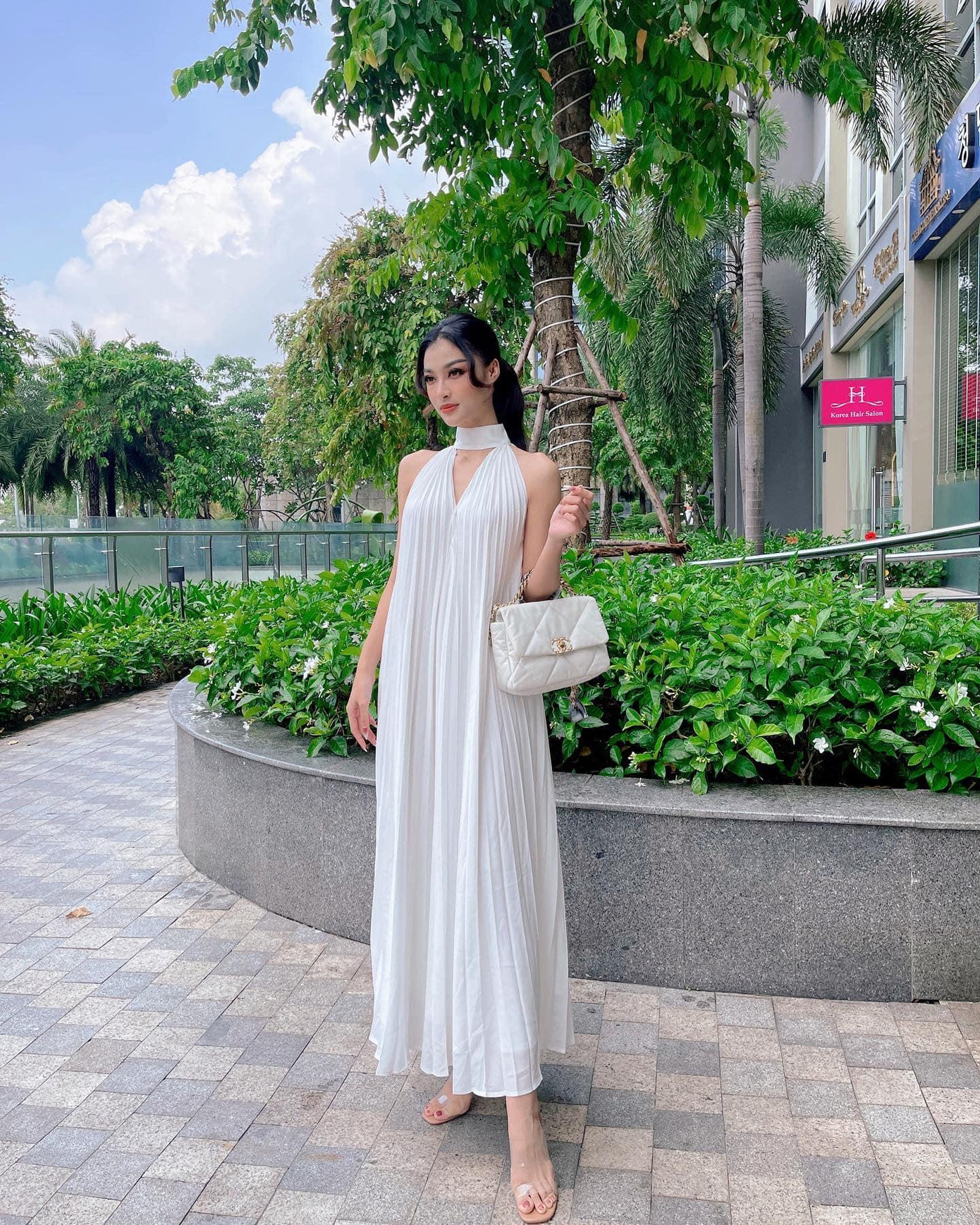 Á hậu Kiều Loan diện bộ váy xếp ly màu trắng thanh lịch, duyên dáng.