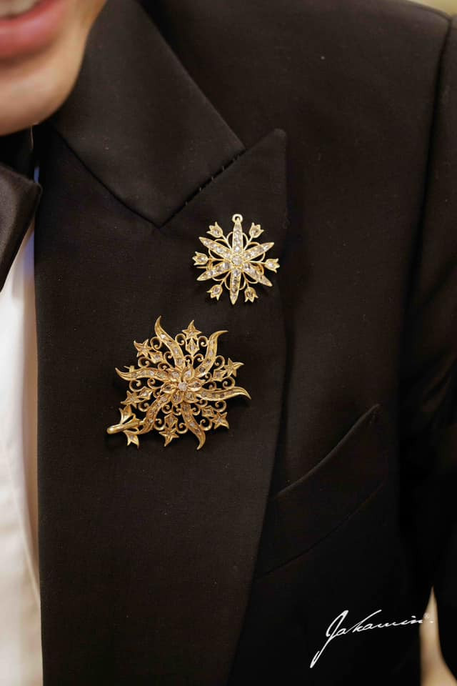 Hai bông hoa vàng đính trên bộ vest lịch lãm của chú rể.