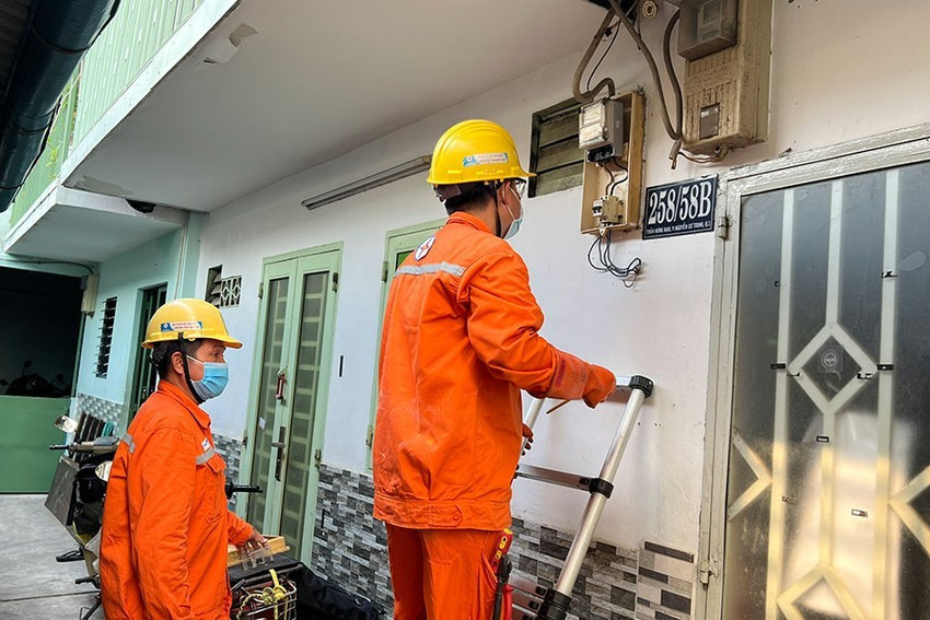 Thợ điện đang kiểm tra chỉ số công tơ. Ảnh: ĐÀO TRANG.