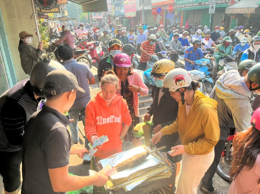 Khách đang chọn mua cá lóc nướng ở một điểm bán khác với giá 220.000 đồng/con.