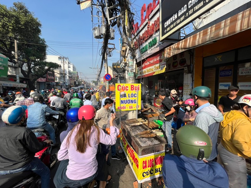 Điểm bán này hết cá lóc lớn, người dân đang chờ mua cá lóc đang nướng giá 220.000 đồng/con.