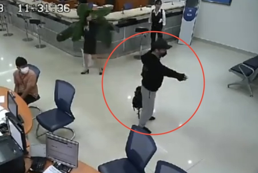 Nguyễn Tấn Phát chĩa súng về phía bảo vệ yêu cầu mở cửa sau khi lấy được tiền (Ảnh: Cắt từ video).