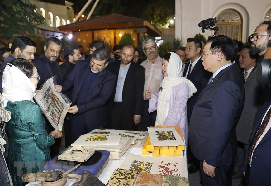 Chủ tịch Quốc hội Vương Đình Huệ và Bộ trưởng Văn hóa và Định hướng Hồi giáo Iran Mohammad Mehdi Esmaili tham quan gian trưng bày, giới thiệu sản phẩm tranh Đông Hồ. (Ảnh: Doãn Tấn/TTXVN)