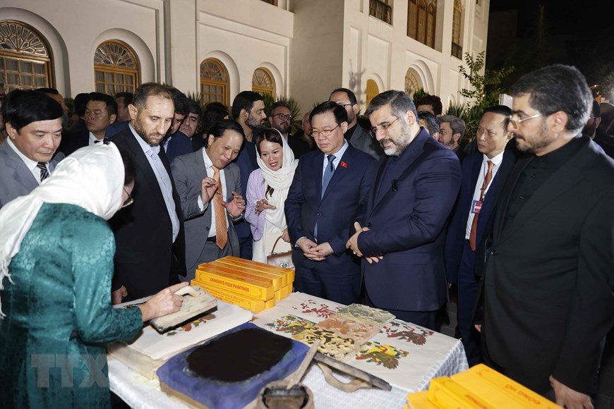 Chủ tịch Quốc hội Vương Đình Huệ và Bộ trưởng Văn hóa và Định hướng Hồi giáo Iran Mohammad Mehdi Esmaili tham quan gian trưng bày, giới thiệu sản phẩm tranh Đông Hồ. (Ảnh: Doãn Tấn/TTXVN)