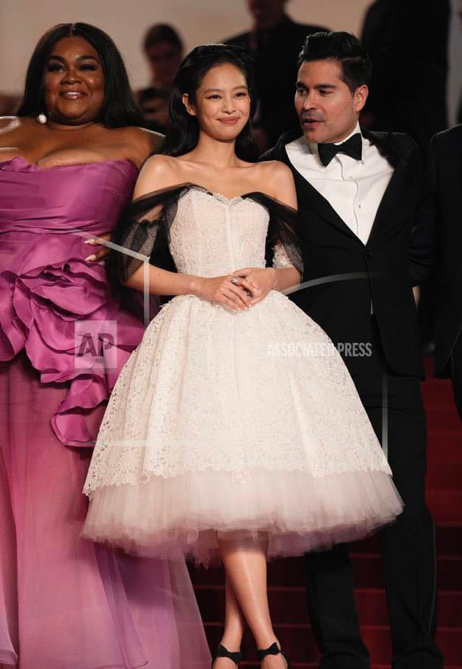 Thần tượng 27 tuổi xuất hiện tại sự kiện với vẻ ngoài lộng lẫy trong chiếc váy couture dài ren trắng kết hợp phần vải tuyn màu đen trễ vai từ bộ sưu tập thời trang cao cấp xuân hè 2020 của hãng hàng cao cấp. Jennie tối giản phụ kiện, chỉ thêm chiếc nơ satin đen trên mái tóc gợn sóng và nhẫn kim cương tinh xảo trên tay.