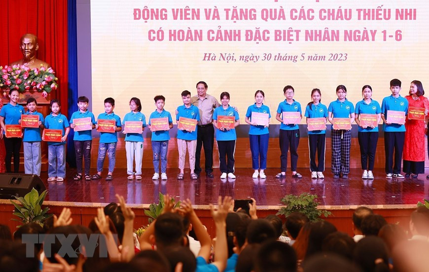 Thủ tướng Phạm Minh Chính trao học bổng cho với học sinh, sinh viên khuyết tật Trung tâm hỗ trợ phát triển giáo dục hòa nhập thuộc Cao đẳng Sư phạm Hà Nội. (Ảnh: Dương Giang/TTXVN)