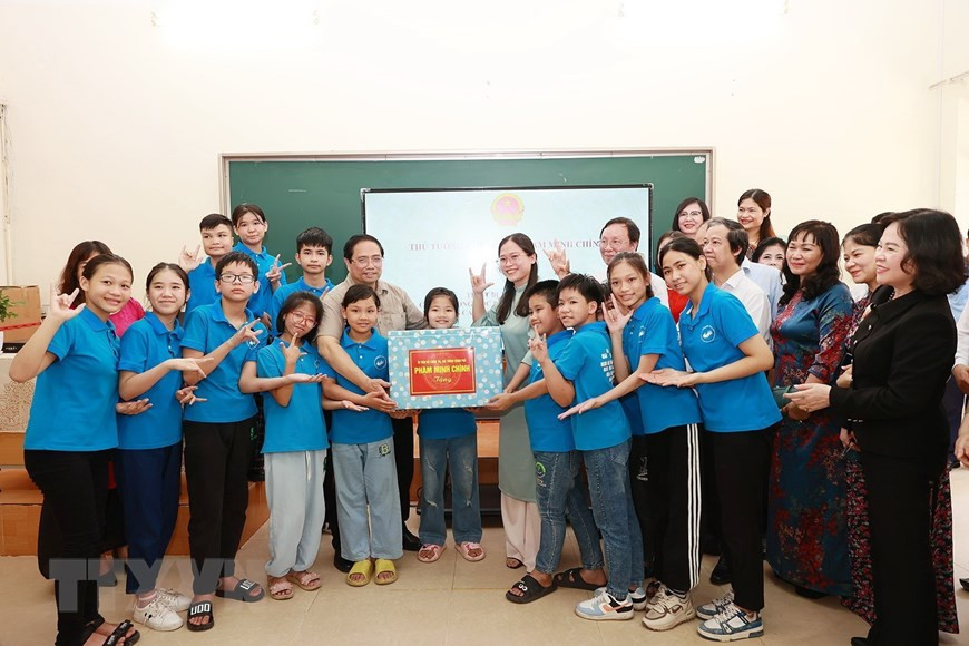 Thủ tướng Phạm Minh Chính tặng quà cho học sinh, sinh viên khuyết tật tại Trung tâm hỗ trợ phát triển giáo dục hòa nhập thuộc Trường Cao đẳng Sư phạm Trung ương. (Ảnh: Dương Giang/TTXVN)