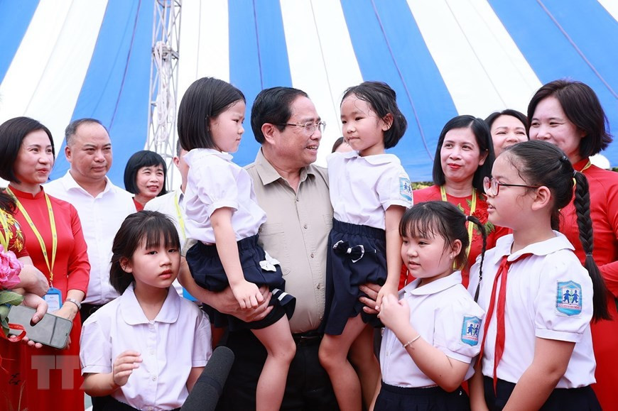 Thủ tướng Phạm Minh Chính thăm học sinh có hoàn cảnh đặc biệt khó khăn của Trường Phổ thông dân lập Herman Gmeiner. (Ảnh: Dương Giang/TTXVN)