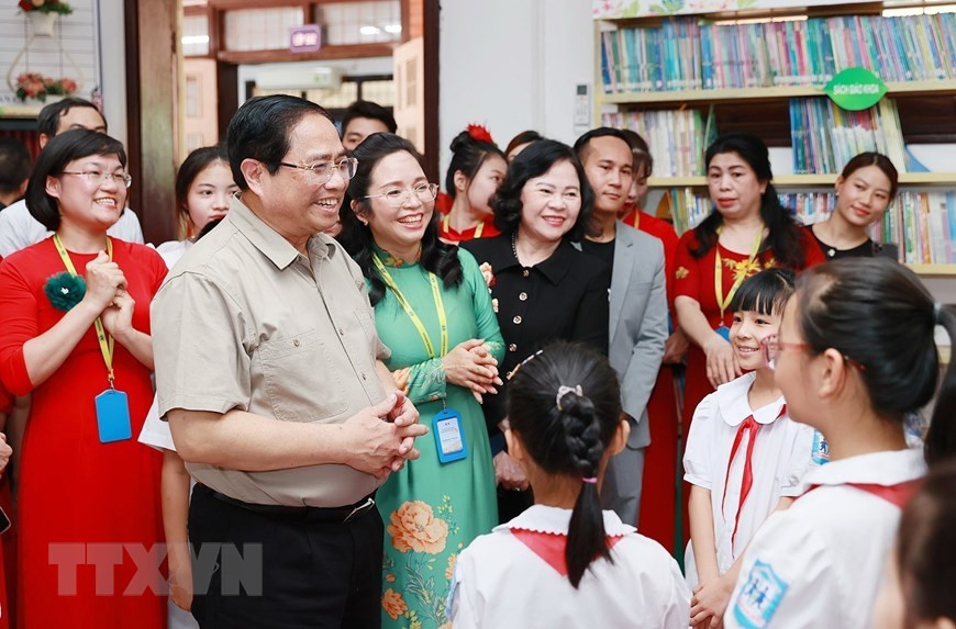 Thủ tướng Phạm Minh Chính thăm, động viên học sinh có hoàn cảnh đặc biệt khó khăn của Trường Phổ thông dân lập Herman Gmeiner. (Ảnh: Dương Giang/TTXVN)