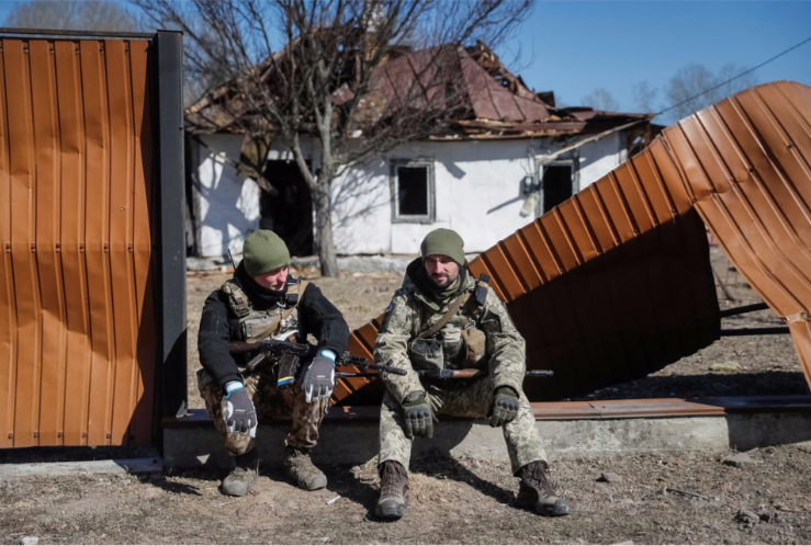 Hai lính Ukraine ngồi ở ngôi làng ngoại ô thủ đô Kiev ngày 21/3. (Ảnh: Reuters) Hai lính Ukraine ngồi ở ngôi làng ngoại ô thủ đô Kiev ngày 21/3. (Ảnh: Reuters)