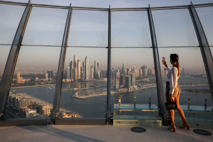 Một phụ nữ đang chụp ảnh bằng điện thoại từ toà tháp ở Dubai. (Ảnh: Reuters) Một phụ nữ đang chụp ảnh bằng điện thoại từ toà tháp ở Dubai. (Ảnh: Reuters)