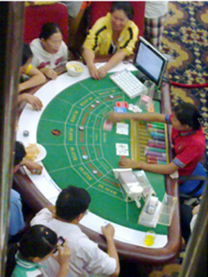 Các con bạc “chân đất” sát phạt nhau trên sòng cào ba lá tại một casino ở Bavet, Campuchia . 