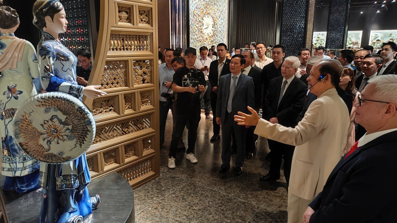 Ông Lý Ngọc Minh (áo trắng, phải) giới thiệu tượng thiếu nữ ba miền bằng sứ tại bảo tàng.