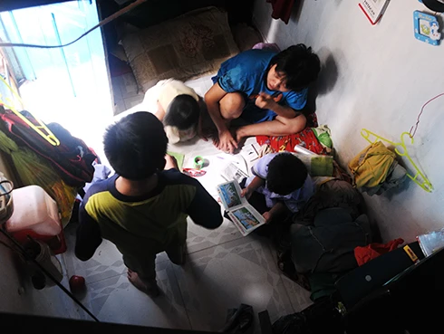 Chị Dung (áo xanh) cùng các con và lỉnh kỉnh vật dụng trong không gian chật hẹp. Ngoài 4 mẹ con, bố mẹ chị cũng sống cùng. 