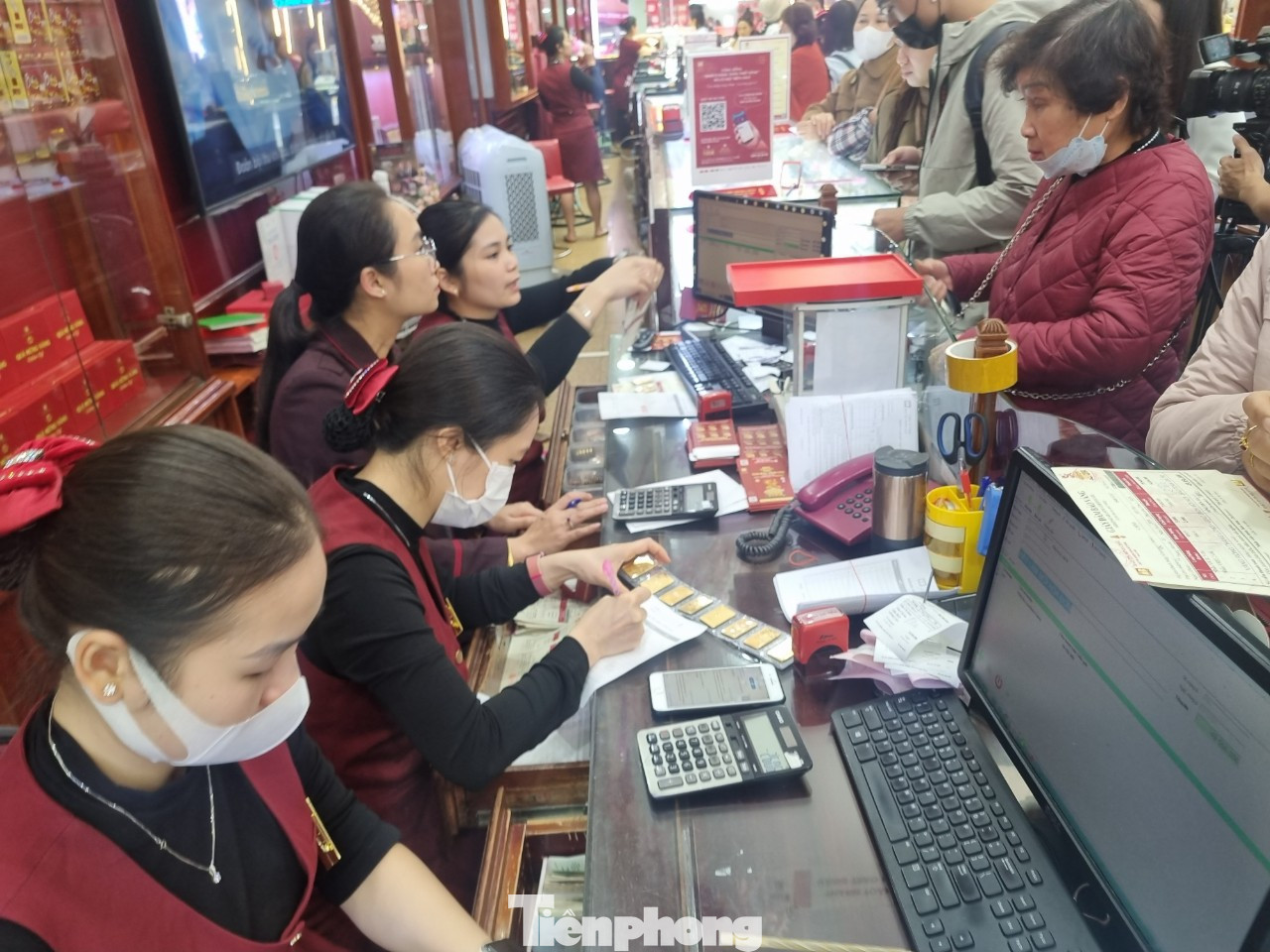 Nhân viên cửa hàng kiểm đếm 9 cây vàng miếng SJC giao cho khách sau khi gom vàng từ cửa hàng khác về (ảnh: Ngọc Mai).