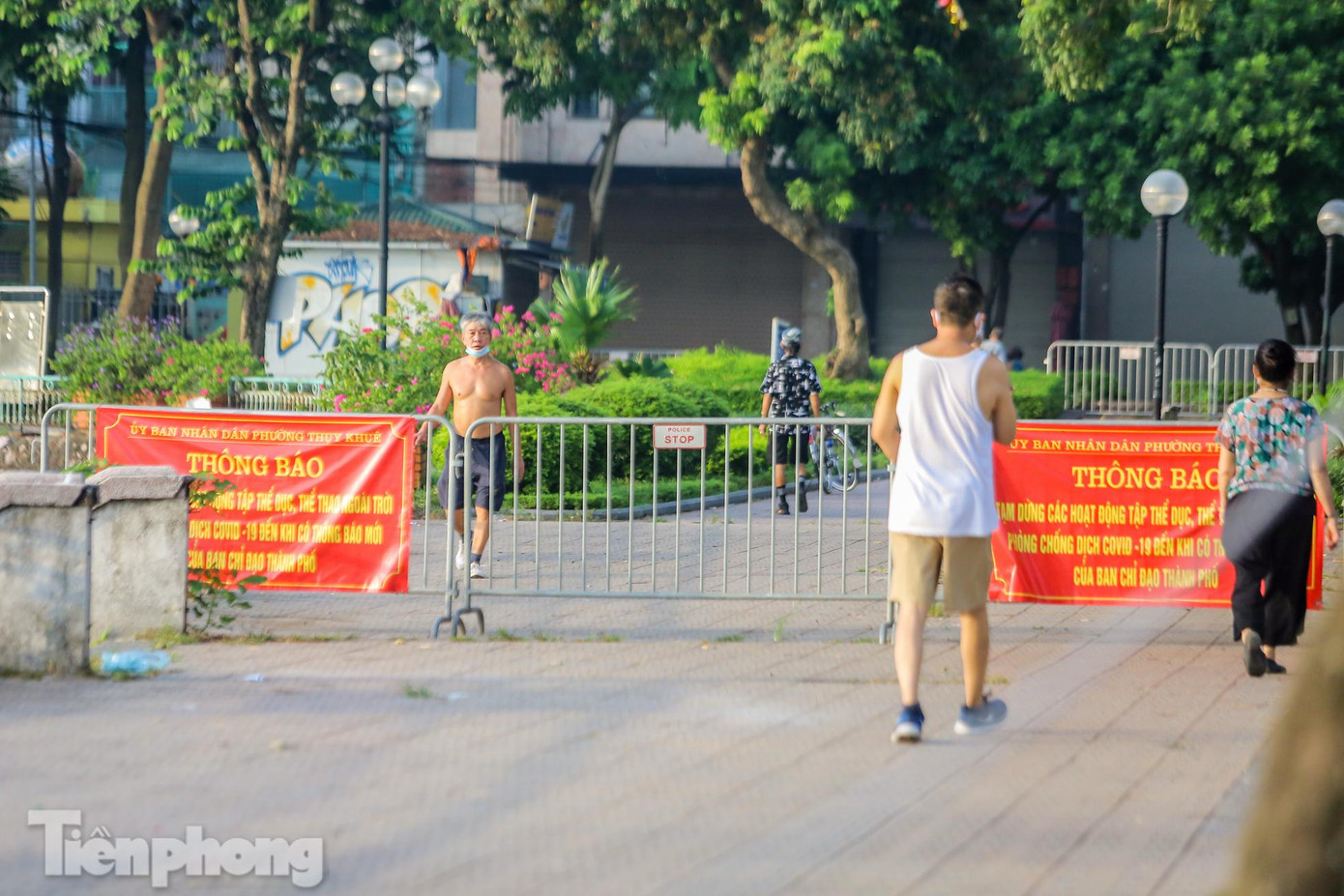 Người dân tập thể dục quanh hồ Trúc Bạch bất chấp hàng rào barie, dây giăng khắp lối.