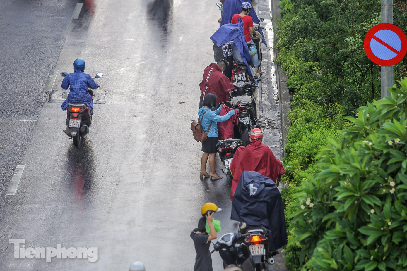 Cơn mưa đến bất chợt khiến nhiều phương tiện tạt vào lề đường mặc áo mưa