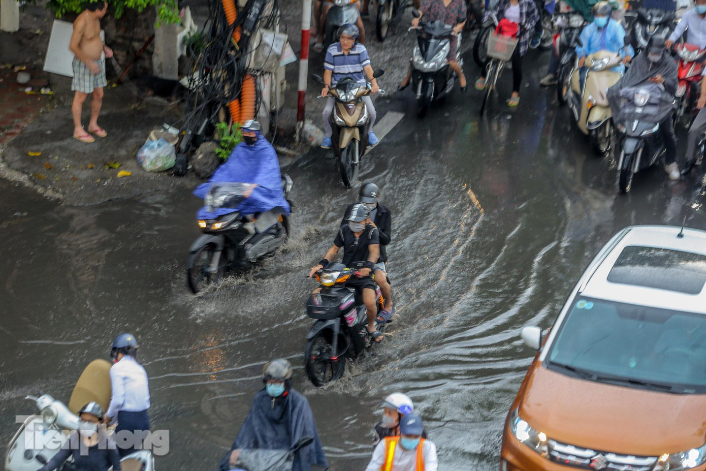 Vũng nước còn đọng lại trên đường sau cơn mưa lớn trên đường Láng khiến các phương tiện di chuyển khó khăn.