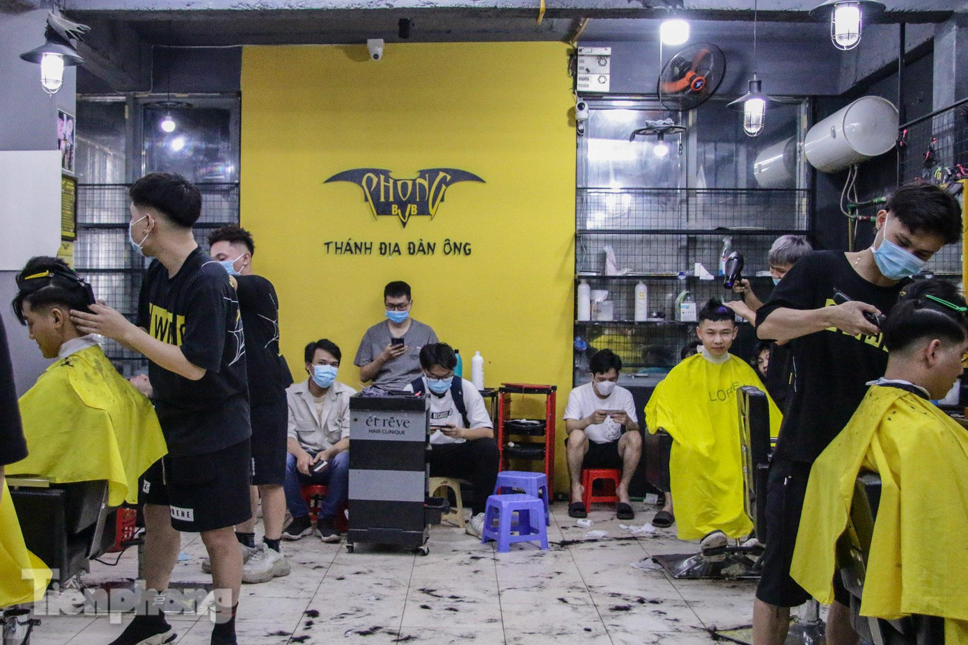 Lượng khách trong một cửa hàng cắt tóc trên đường Láng tăng đột biến trước ngày tạm dừng.