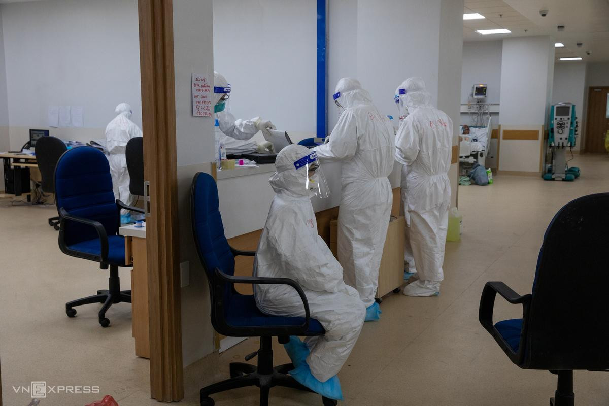 Một điều dưỡng tranh thủ ngồi nghỉ, hướng mắt về phía giường bệnh theo dõi bệnh nhân.