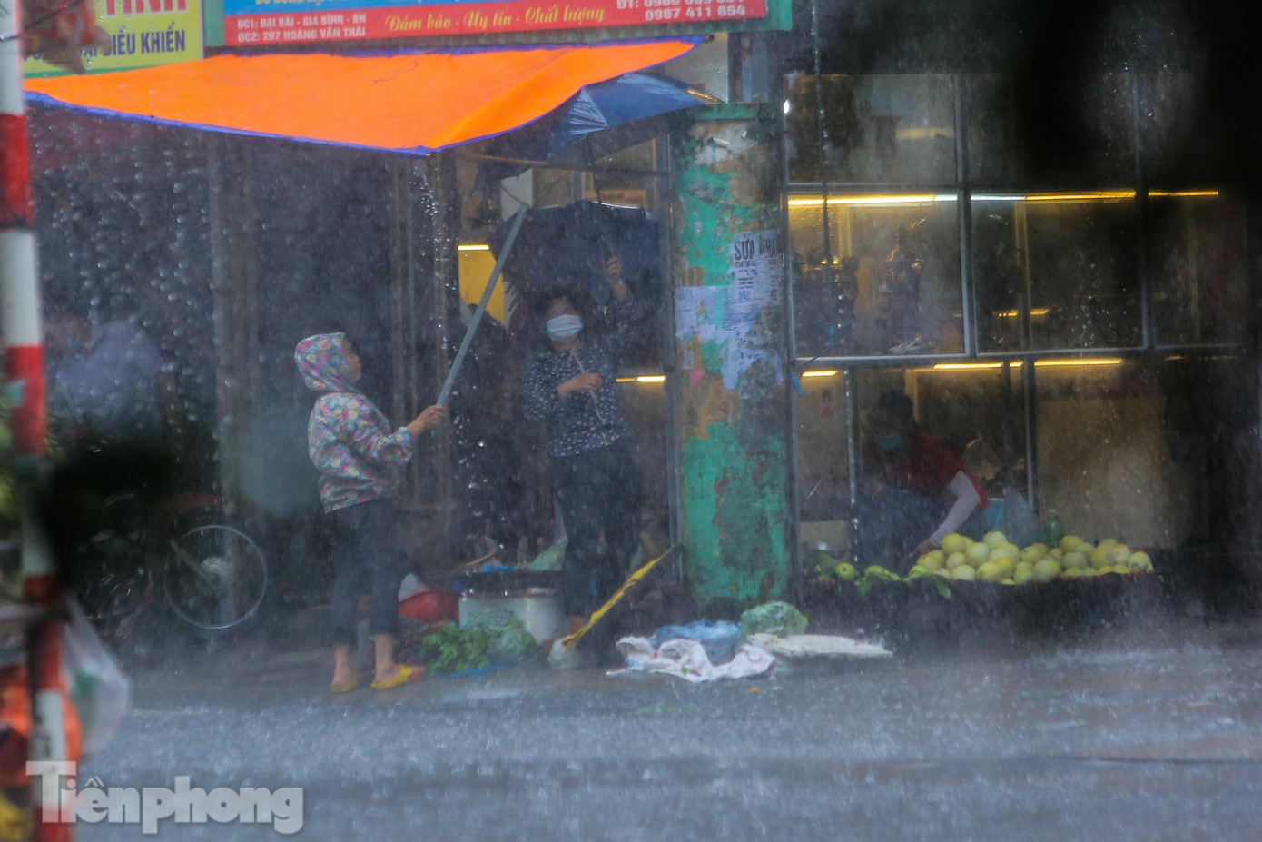 Các tiểu thương vội giăng bạt che chắn hàng hoá, thực phẩm.