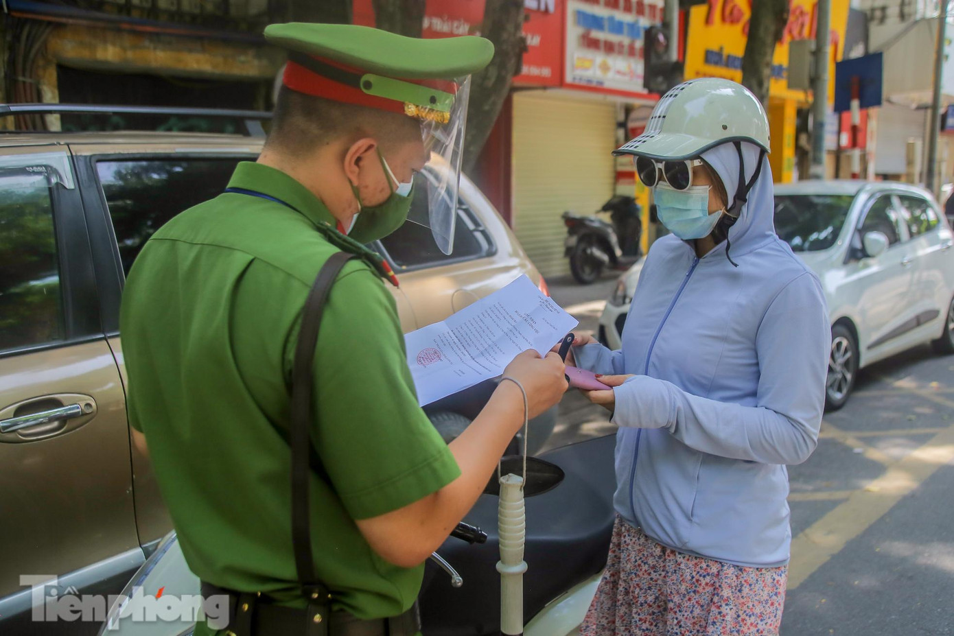 Nhiều người dân xuất trình giấy xác nhận cơ quan để tiếp tục được lưu thông trên đường.