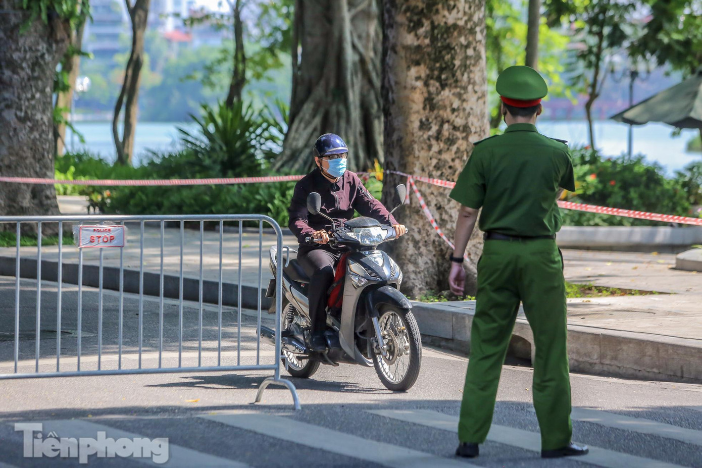 Lực lượng chức năng kiểm tra giấy tờ tùy thân và xác nhận đi làm, ra ngoài của cơ quan với người dân lưu thông trên đường.