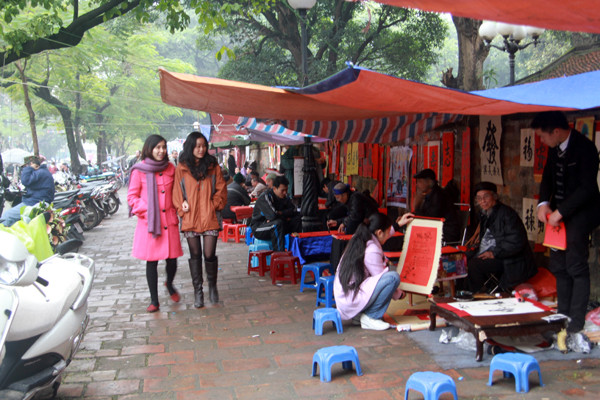 Mặc dù lất phất mưa nhưng phố ông đồ - gần Văn Miếu vẫn thu nhộn nhịp khách đến 