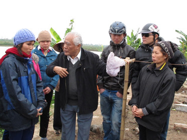 Phó chủ tịch Hội Nghề cá Việt Nam Võ Văn Trác (thứ ba từ trái qua) thăm hỏi vợ con ông Quý, ông Vươn ngay trên nền đất của căn nhà hai tầng đã bị phá hủy. Ảnh: Thân Hoàng