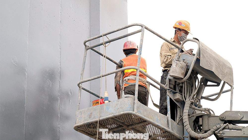 Công nhân đang chỉnh trang, đánh bóng và sơn phủ những trụ đường trên toàn bộ công trình.