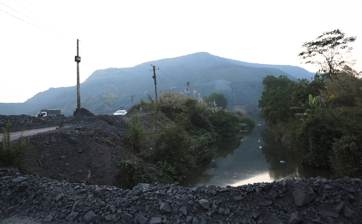 Con suối ngăn cách khu vực còn các hộ dân sinh sống với khu bãi thải mỏ than. Ảnh: Hân Nguyễn.