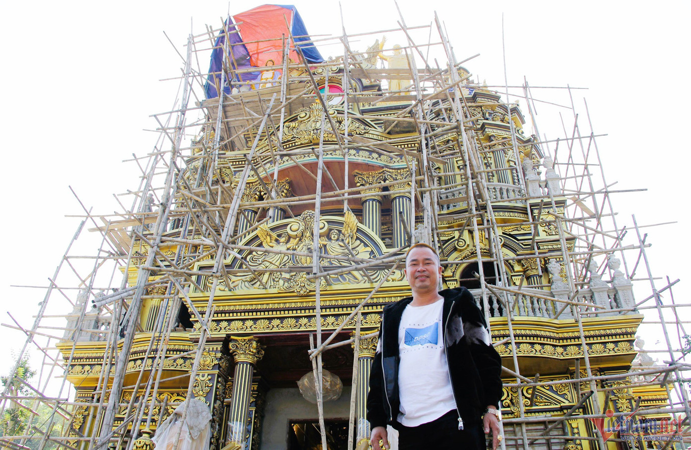 Ông Thoan bên tòa nhà đang dần hoàn thiện