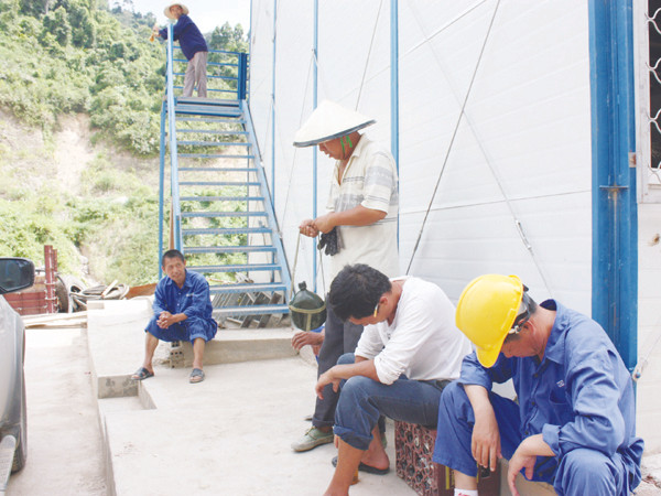 Nhóm công nhân Trung Quốc ngồi tán chuyện trên công trường xây dựng Thủy điện sông Bung. Ảnh: Nam Cường