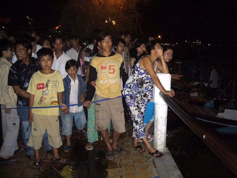 Hàng trăm người dân vẫn kiên trì chờ đợi thông tin về người thân ngay tại hiện trường trong màn đêm buông xuống. Ảnh: Hữu Quang